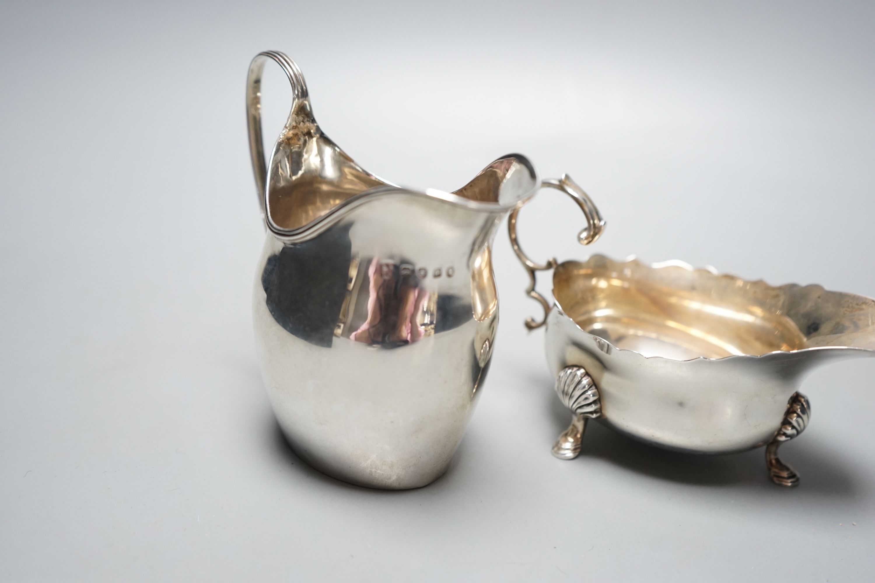 A George III silver jug, London, 1798, a silver sauce boat and pair of silver mounted dwarf candlesticks.